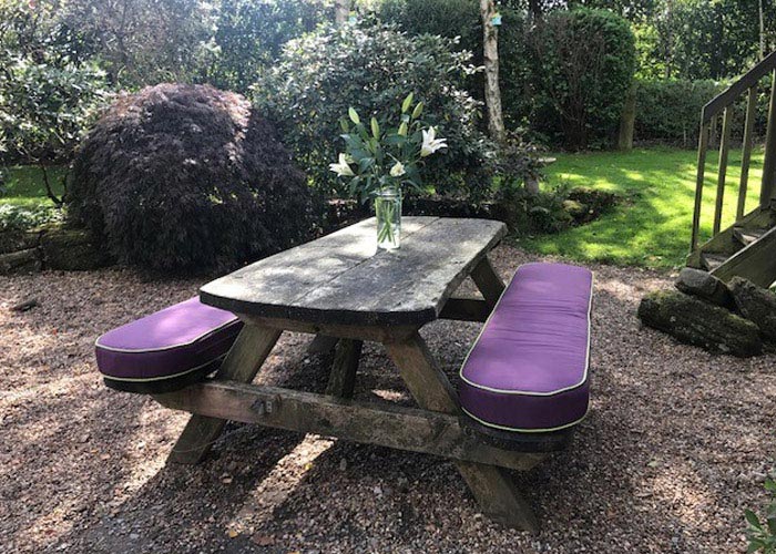 Outdoor seat cushions for a wooden picnic table